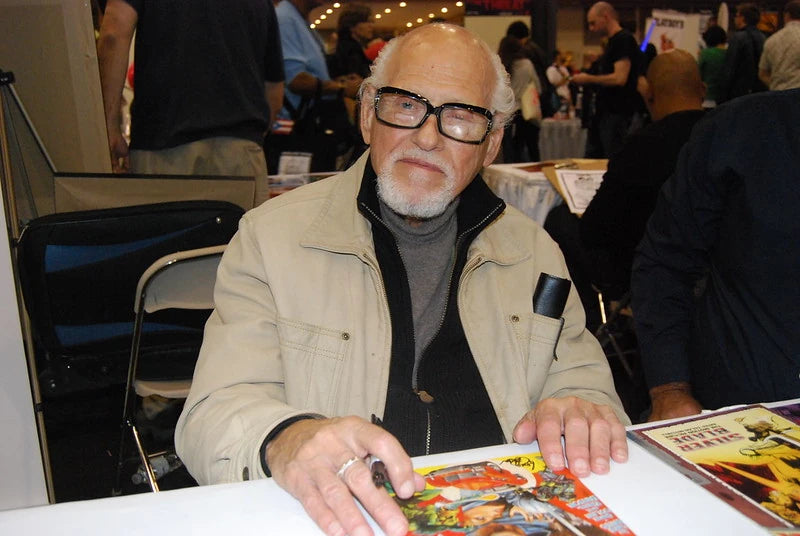 Gene Colan sitzt vor einem Comicheft